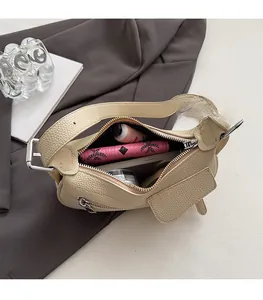 Spacious interior of beige lychee leather crescent bag with essentials shown