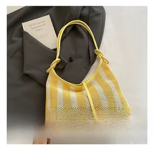 Détail du sac en filet à rayures jaunes et blanches avec bandoulière à nœud décoratif