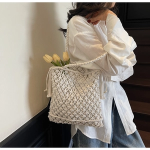 Détail du tissage macramé blanc cassé avec de longues franges sur le sac fourre-tout