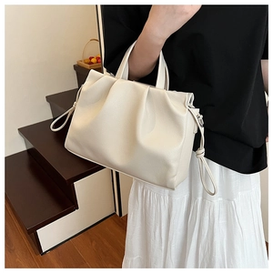 Detail of soft cream-colored pleated cloud tote bag with side drawstring details