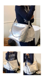 Detail of silver metallic bucket bag with quilted texture, chain, and metal rivets