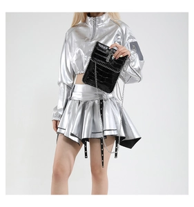 Détail du sac bandoulière noir effet croco avec croix en métal et tenue punk argent