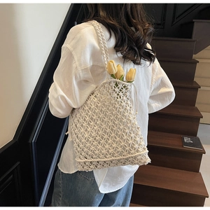 Gros plan d'un sac cabas blanc en macramé tressé avec motif ajouré et tulipes
