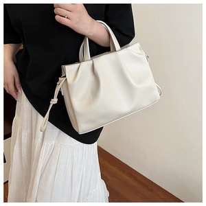 Close-up of off-white lychee leather shoulder bag with stylish pleats and soft texture
