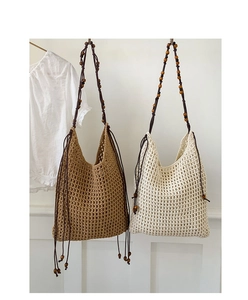Detailansicht handgefertigter Häkel-Tote-Bags mit Holzperlen und langen Fransen-Quasten