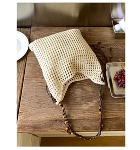Detail der handgewebten Netztasche mit bunten Holzperlen an den Riemen und Boho-Styling
