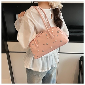 Detail view of pink shoulder bag featuring pearl accents and star-shaped metal studs