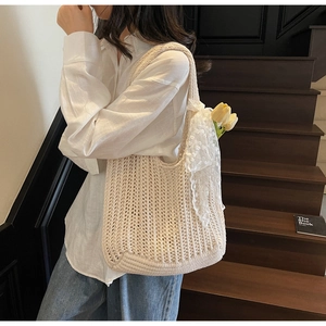 Detail of beige hand-woven crochet tote bag featuring lace ribbon and hollow texture