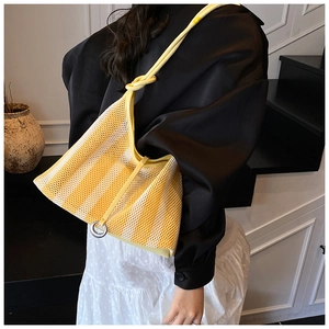 Detail of yellow and white striped mesh tote bag with knotted strap and metal ring