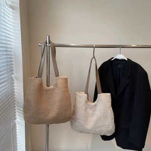 Woven straw tote bag in dark brown and beige with leather shoulder straps for summer