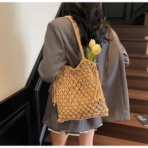 Vue détaillée du sac cabas en crochet moutarde avec de longues franges et maille ajourée