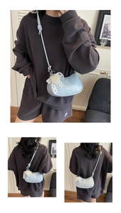 Light blue half-moon crossbody bag with pearl lace charm and knotted strap detail