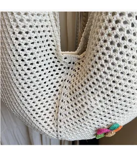 Close-up of beige crochet tote bag with woven bow detail and bohemian textures