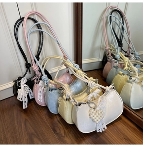 Detail of colorful mini dumpling bags with pearl heart charms and knotted straps
