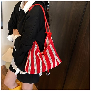 Detail of red and white striped mesh tote bag with leather straps and metal ring charm