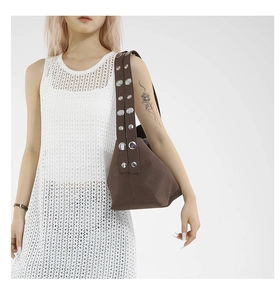 Detail of vintage matte crossbody bag with wide shoulder strap and silver metal rivets