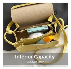 Detail view of the yellow crossbody bag interior showing phone and makeup capacity