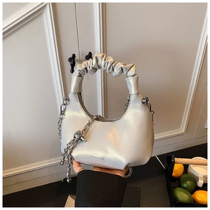 Detail of pleated handle and silver chain on pearl white crescent shoulder bag