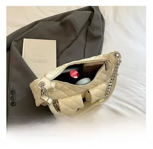 Detail view of cream quilted shoulder bag showing interior capacity for phone and cosmetics