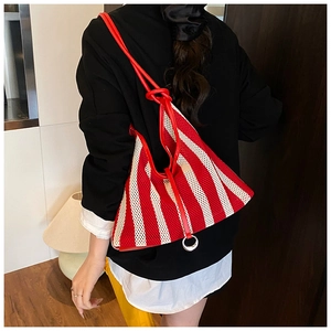 Detail of red and white striped mesh tote bag with knotted shoulder strap and ring detail