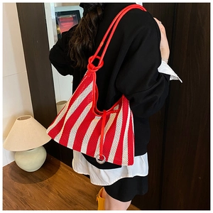 Détail du sac cabas en maille à rayures rouges et blanches avec bandoulière rouge