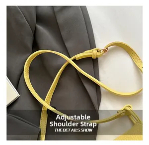 Close-up of adjustable yellow lychee leather shoulder strap with gold buckle detail
