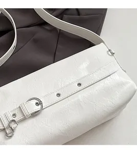 Detail of white wrinkled leather shoulder bag with silver eyelets and buckle accents