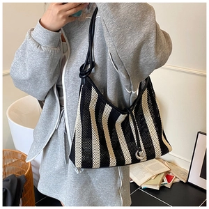 Detailed view of striped woven mesh shoulder bag with knot strap and metallic ring