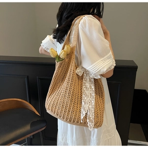 Macro detail of the woven hollow structure and white lace ribbon on the beige tote bag