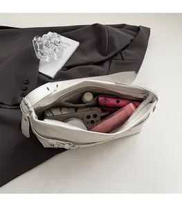 Internal view of a spacious cream PU leather tote bag with a zipper and personal items