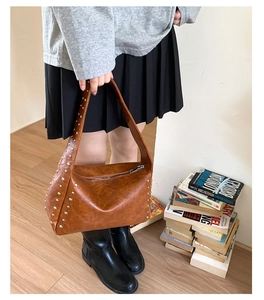 Details der braunen Vintage-Umhängetasche mit silbernen Nieten und Kunstlederstruktur