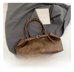 Κοντινό πλάνο vintage καφέ τσάντας tote με μεταλλικές αγκράφες σε υφασμάτινο φόντο