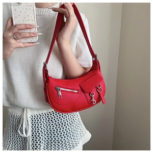 Detail of red crescent shoulder bag with lychee grain leather and silver metal zippers