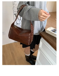 Nahaufnahme der braunen Vintage PU-Schultertasche mit silbernen Nieten und Reißverschluss
