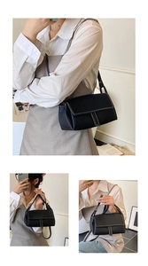 Detail of black lychee pattern leather bag with white decorative stitching accents