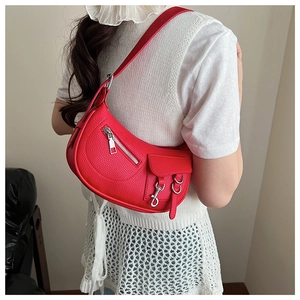 Detail of red lychee textured half-moon shoulder bag with silver metallic hardware accents