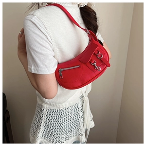 Detail shot of a vibrant red lychee pattern leather shoulder bag with silver hardware