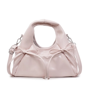 Pink crossbody dumpling bag with bow-knot pleats and adjustable strap on white background