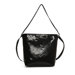 Fashionable black quilted bucket bag with silver studs and chain strap on white background