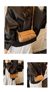 Detailed view of brown litchi grain leather shoulder bag with adjustable strap on model