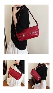 Close-up of red patent leather underarm bag with silver buckle and adjustable strap