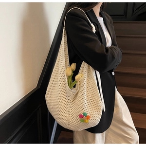 Detail of crochet shoulder bag with colorful floral patch and hollow woven texture