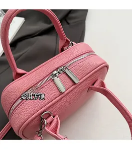 Detail of pink lychee leather handbag showing smooth silver double zipper hardware