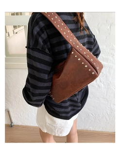 Details der braunen PU-Ledertasche mit silbernen Nieten und breitem Schulterriemen