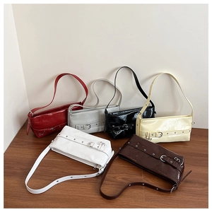 Close-up of gloss leather underarm bags in six colors with decorative buckle details