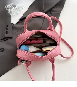 Top view of pink leather bag interior showing spacious capacity for cosmetics and phone