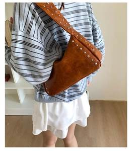 Detail der braunen Vintage-Schultertasche mit silbernen Nieten und Lederstruktur im Used-Look
