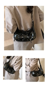 Nahaufnahme der schwarzen Lackleder-Hobo-Tasche mit Schnürungen und Metallösen