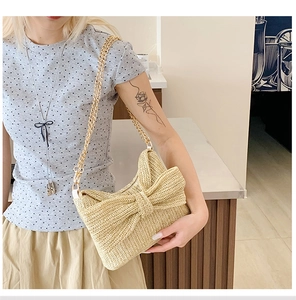 Detail der Sommer Strohtasche mit gewebter Schleife und goldener Ketten-Schulterriemen