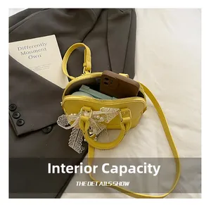 Detail view of yellow Boston bag interior showing capacity for phone and makeup